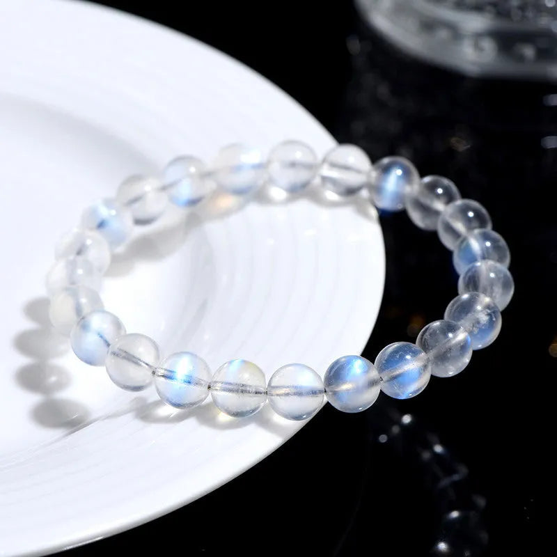 Natural blue moonlight cream body crystal bracelet on a wrist, showing polished beads.