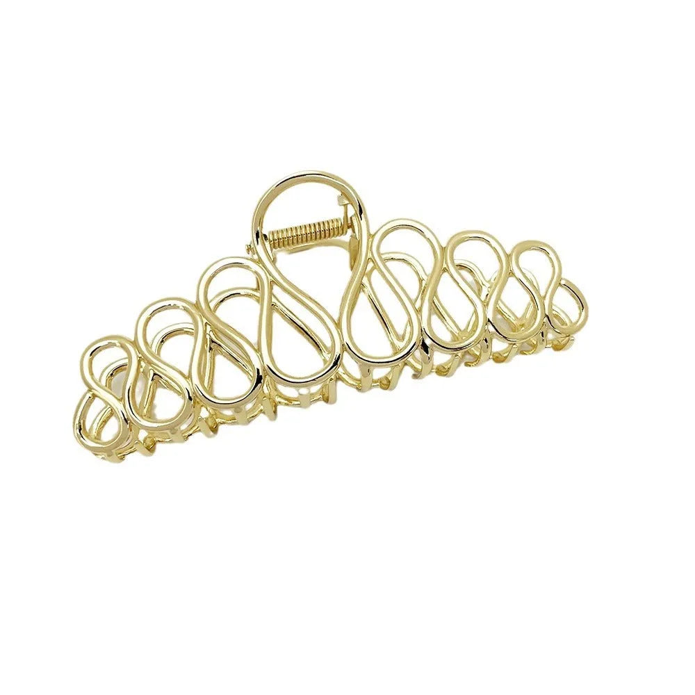 Large gold and silver alloy hair clip with a tassel detail on a white background.