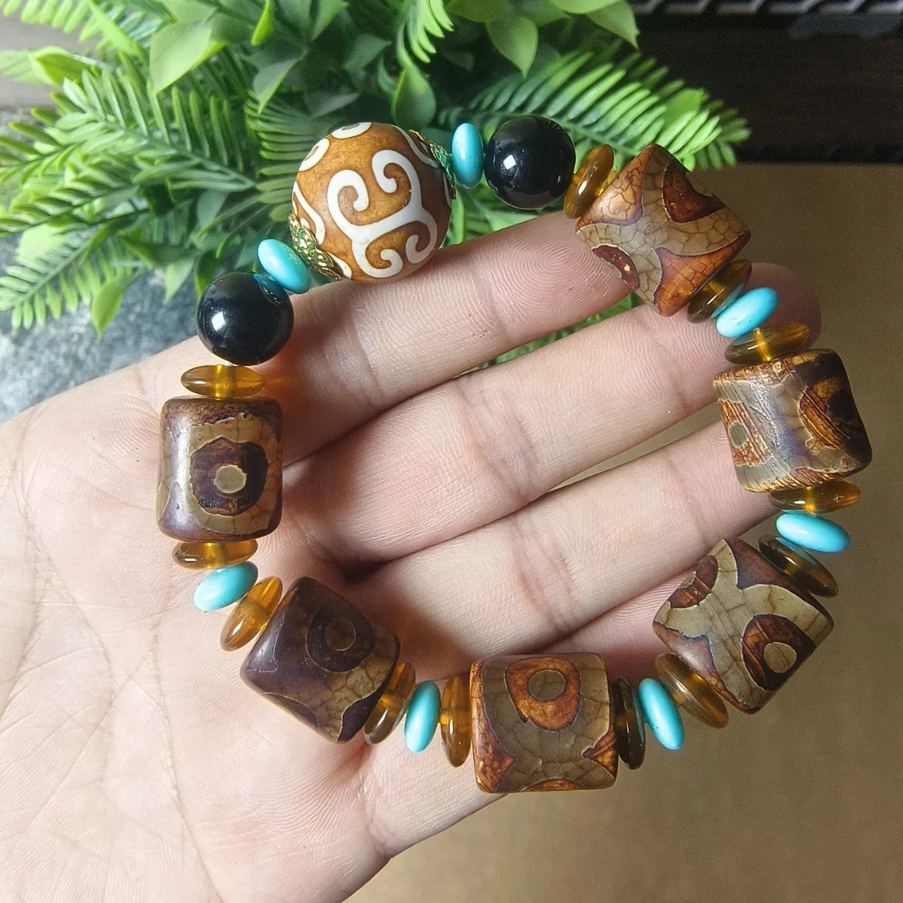 Distressed agate Tibet bead bracelet with three-eye motifs and multiple traditional bead styles on wrist