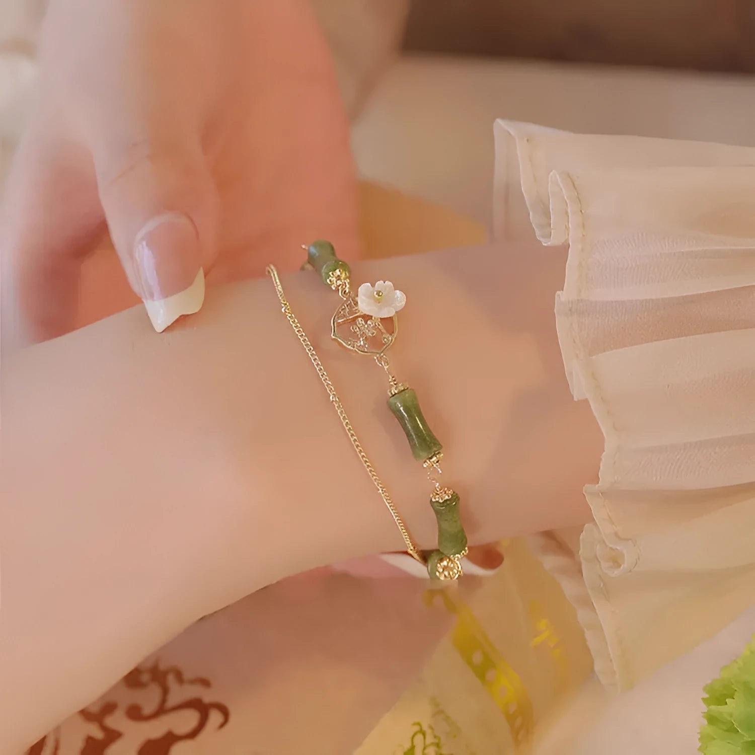 Handmade natural olivine bracelet with double layer design and Bells of Ireland charms on a wrist.