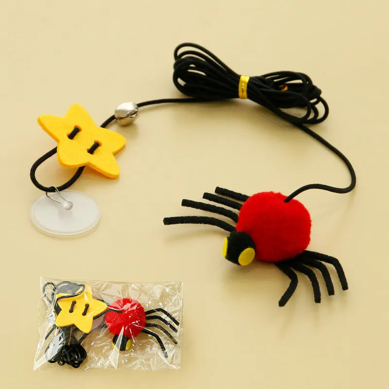 Red and yellow hanging cat toy with elastic rope, feathers, and a bell spider attached to a door.