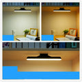 Modern plastic LED desk lamp with touch controls and built-in battery on wooden desk