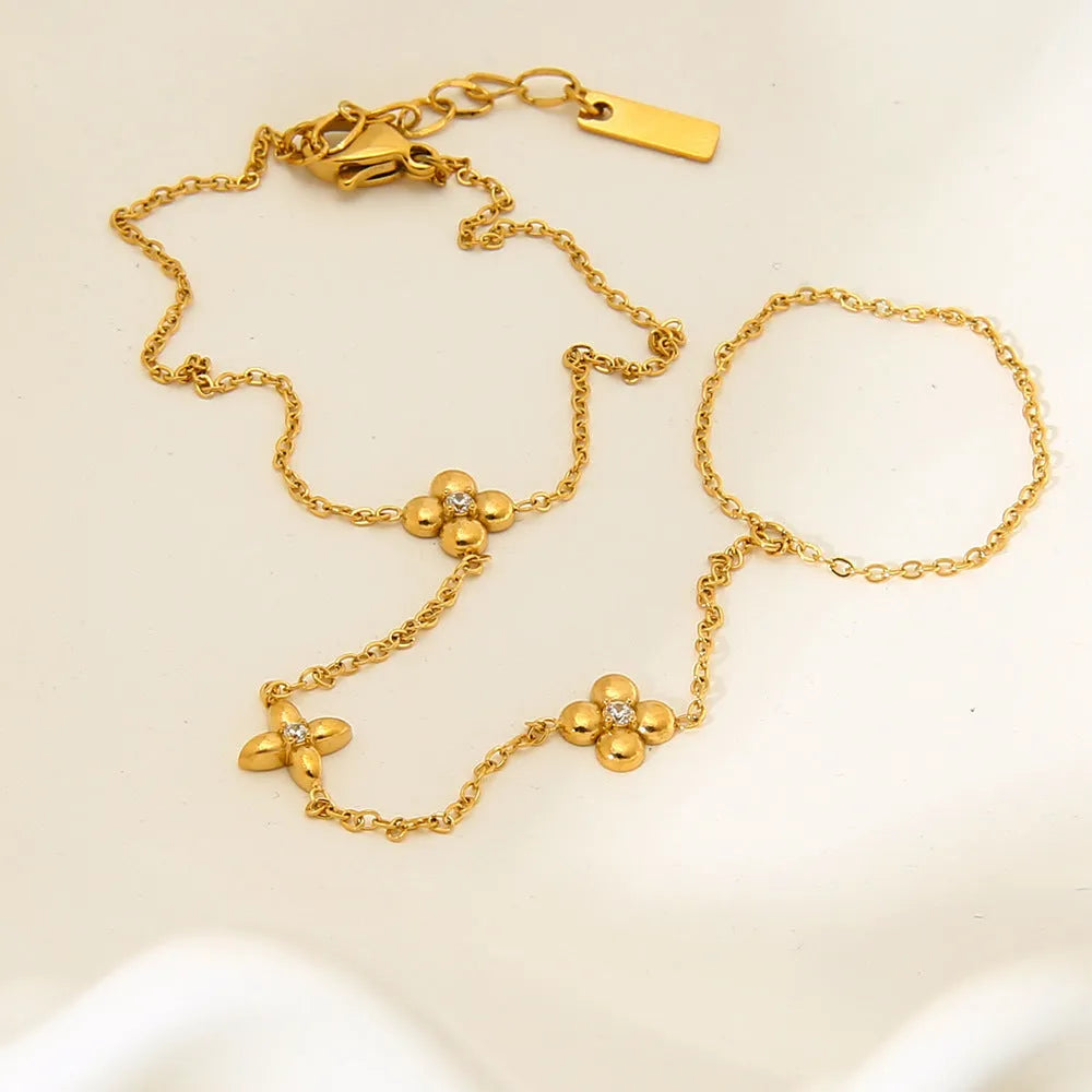 Gold-coloured stainless steel women's bracelet with eight-pointed star shape and floral decorative elements