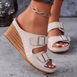 Women's creamy white beach slippers with a silver buckle on the strap