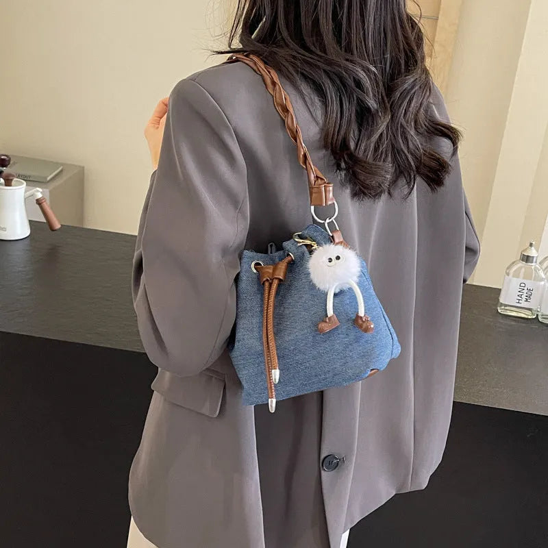Blue one-shoulder cross body bucket bag with messenger style design and synthetic leather lining