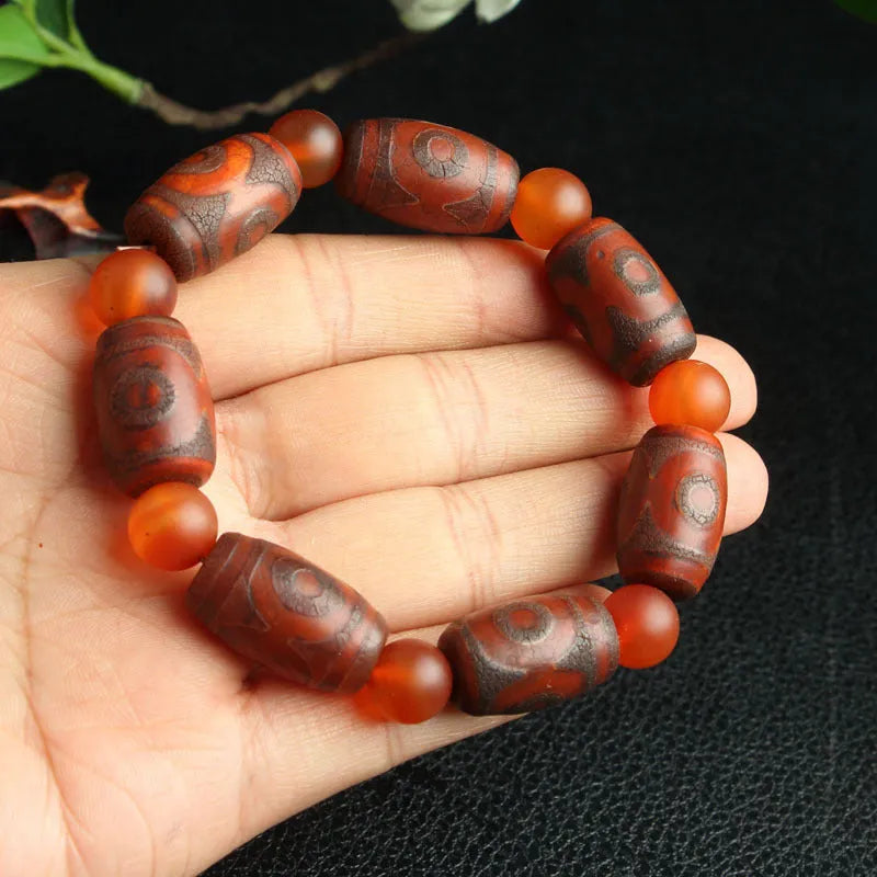Distressed agate Tibet bead bracelet with three-eye motifs and multiple traditional bead styles on wrist