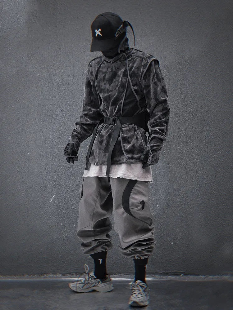 Man wearing a black and grey tie dye printed sweater with a finger turtleneck and drop shoulder sleeves.