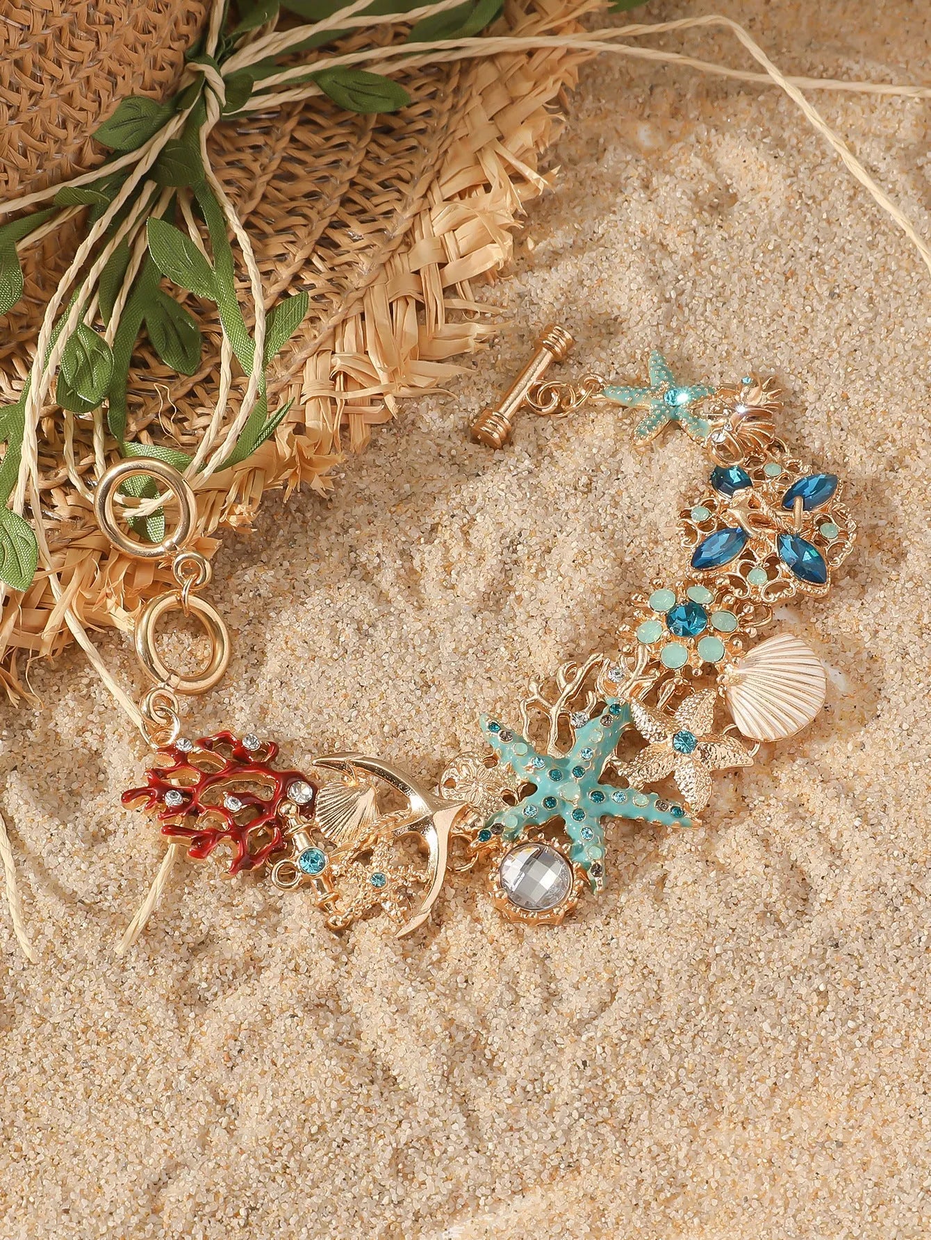 Starfish-shaped alloy bracelet with rhinestone anchor and shell details in turquoise, red, or blue.