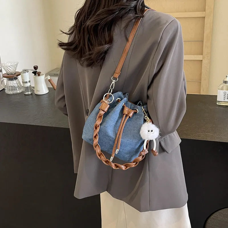 Blue one-shoulder cross body bucket bag with messenger style design and synthetic leather lining