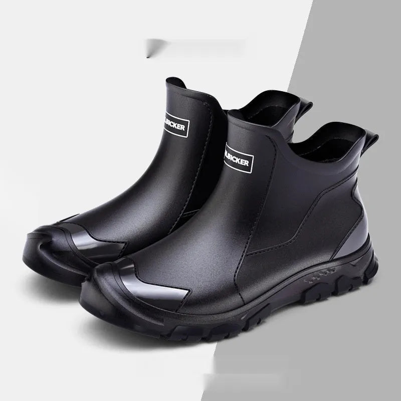 Short black PVC wading boots with a round toe and flat heel on a white background.