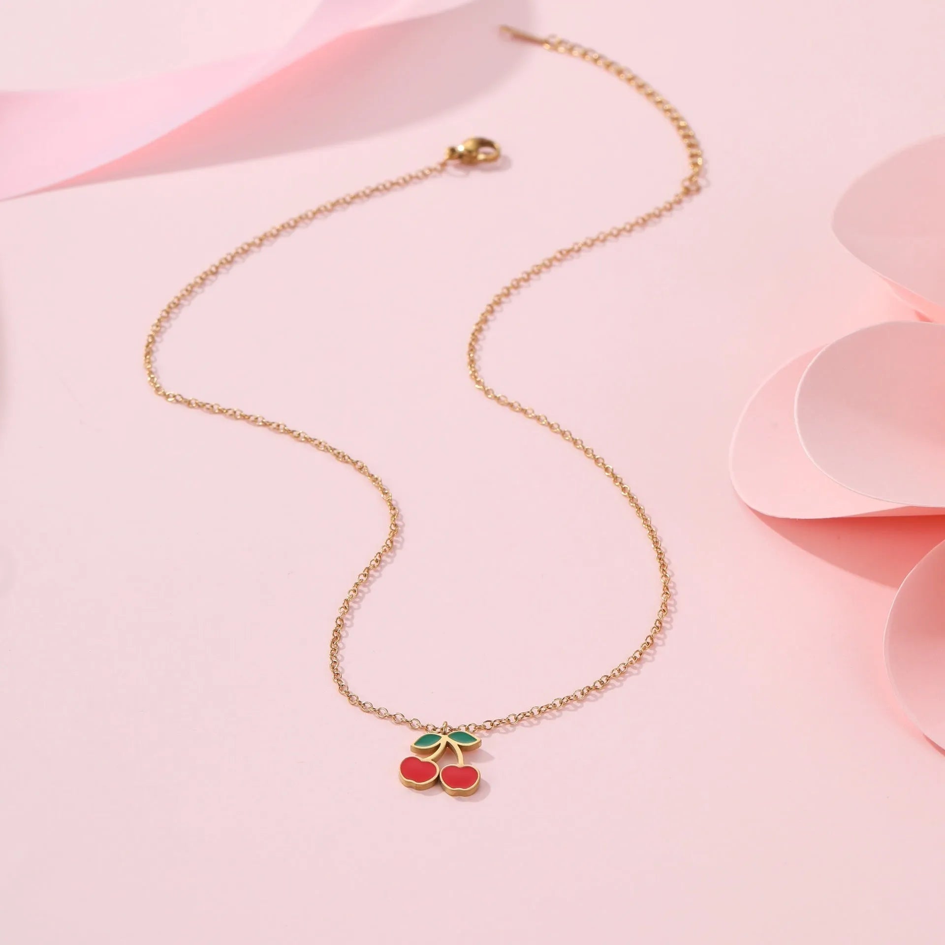 Cherry jewellery set showing necklace, bracelet, earrings, and ring with stainless steel construction and cherry motifs