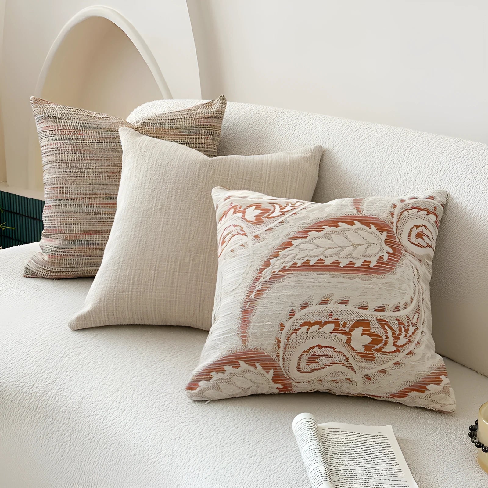 Amber jacquard paisley pillow cover on a sofa, showing textured fabric and botanical pattern.