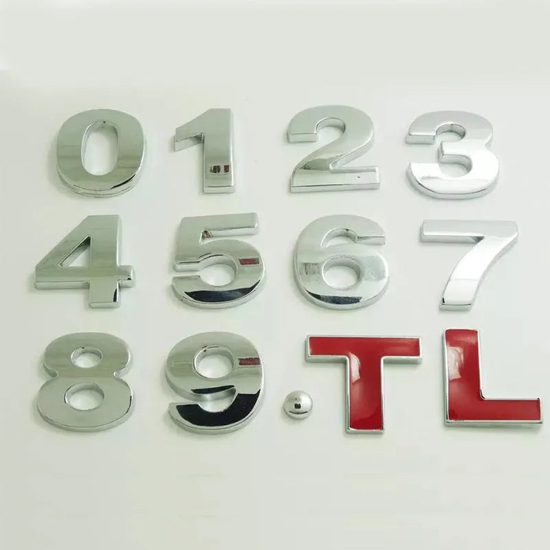 Close-up of a silver metal 3D letter 'A' car sticker with adhesive backing, shown next to a black version.