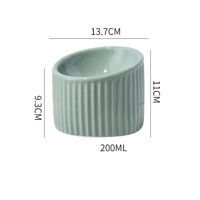 Ceramic elevated cat bowl in green or yellow with a tilted, round, whisker-friendly design.