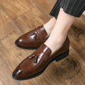 Men's black slip-on business casual shoes with a tassel detail and pointed toe.