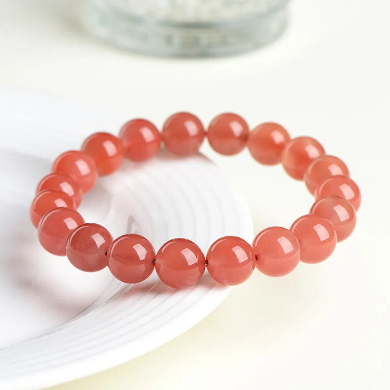 Natural cherry red agate scattered bead bracelet with polished stones on an adjustable strap.