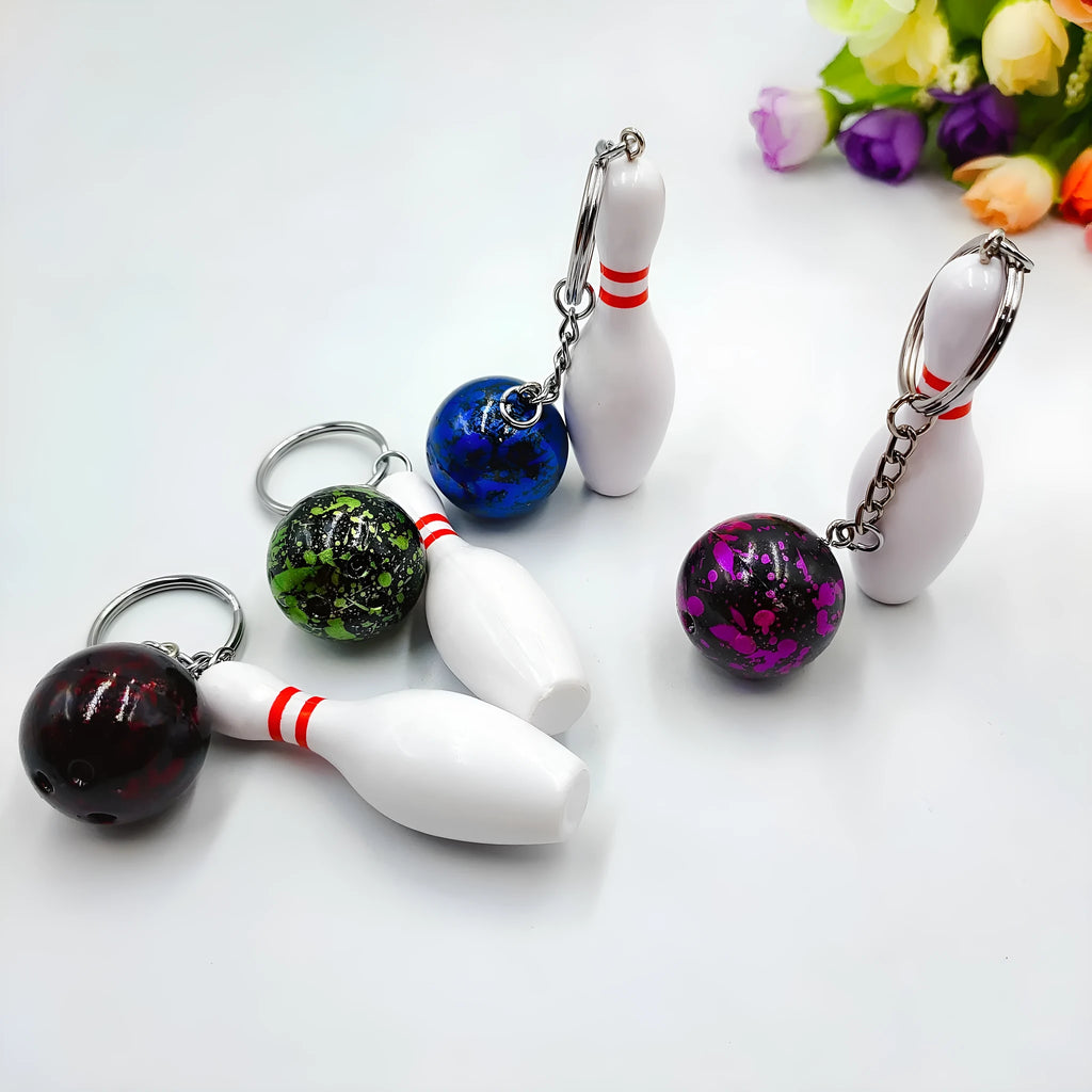 Mini bowling ball keychain pendant in PVC metal showing four colour options: dark red, blue, purple, green
