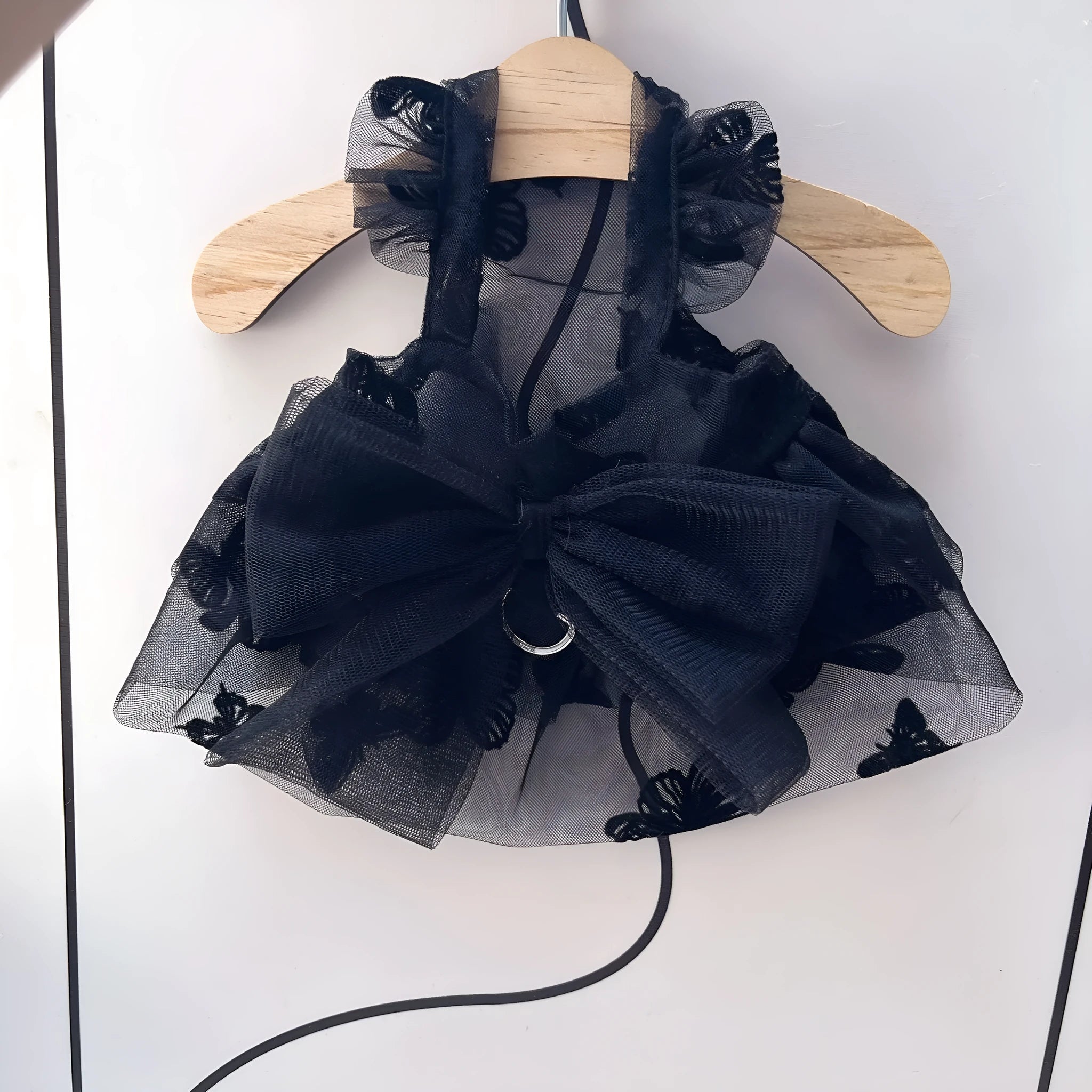 Black polyester tulle princess skirt for a small dog or cat on a hanger.