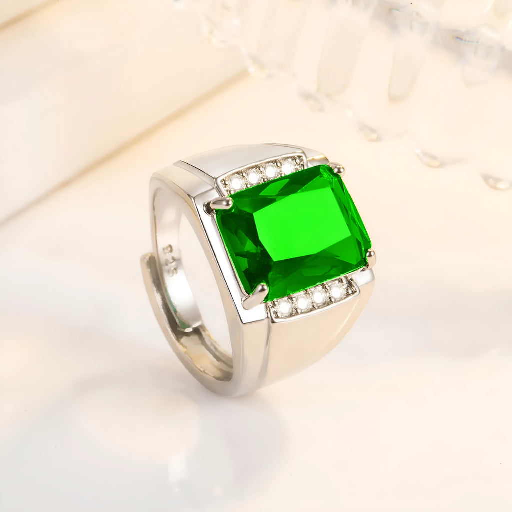 Adjustable open geometric ring with a coloured rhinestone stone on a copper band with plated finish.