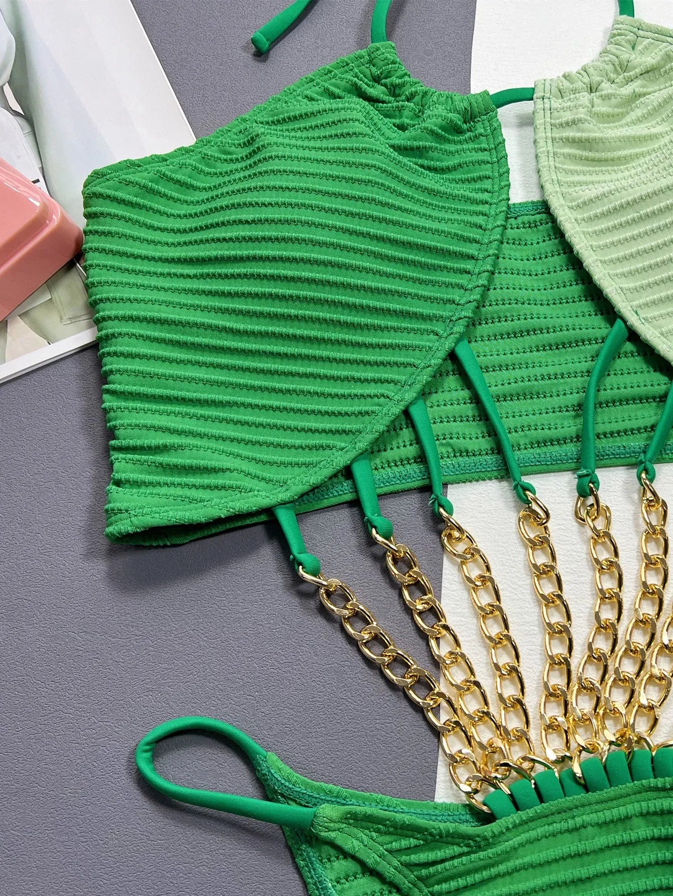 Green women's one-piece swimsuit with a hollow design on a solid colour background.