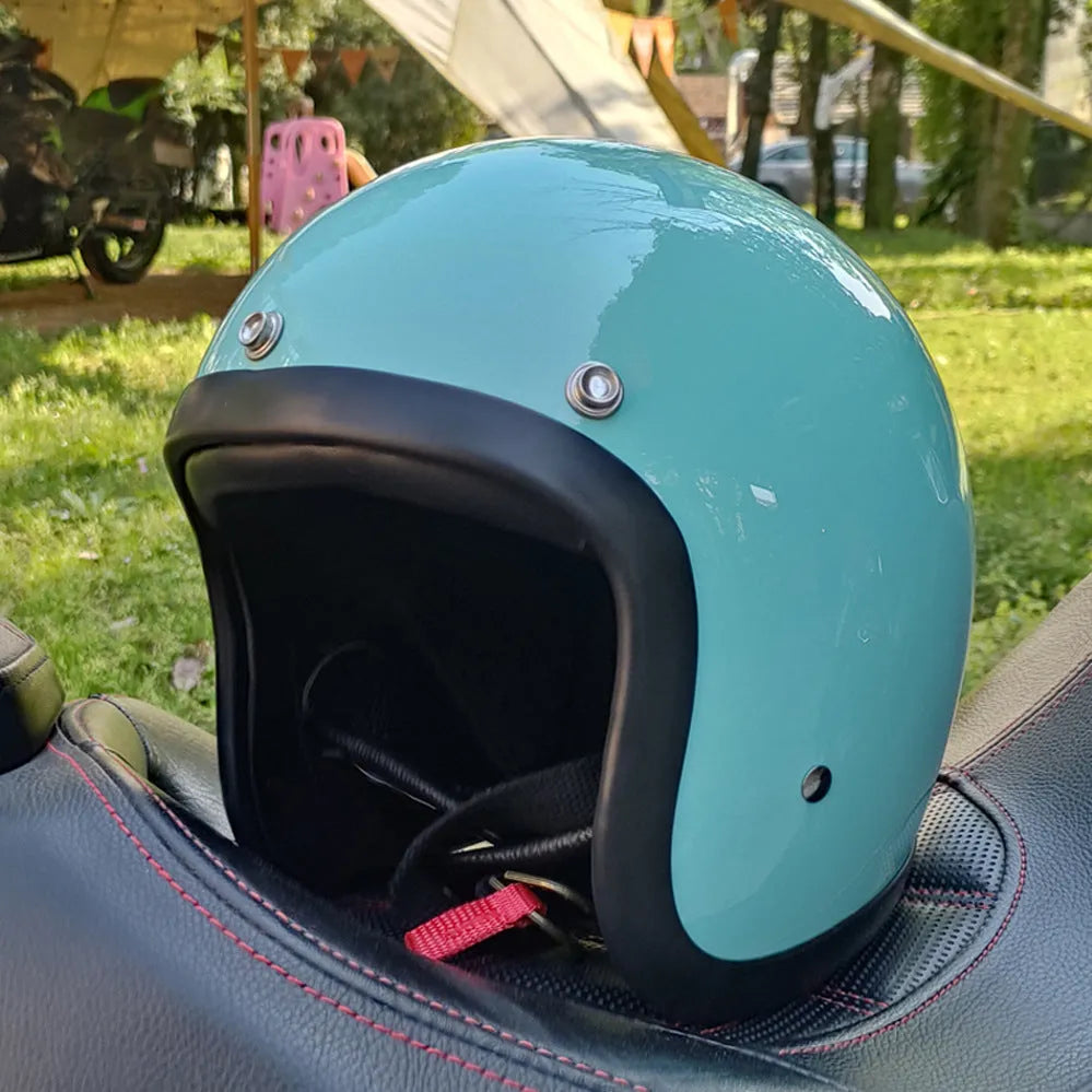 A retro-style motorcycle half helmet made from grey fibreglass, shown from the side.