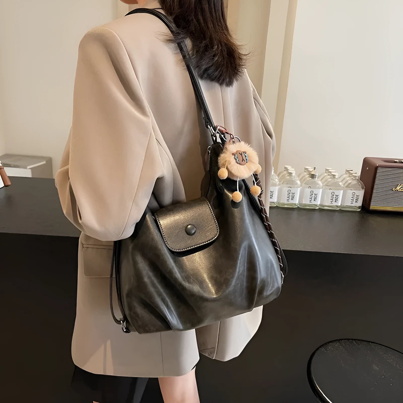 Textured PU leather commuter backpack with single shoulder strap and internal mobile phone pocket