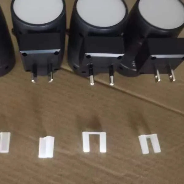 Small white induction night lamp plugged into wall socket with adjustable brightness and rotatable warm light