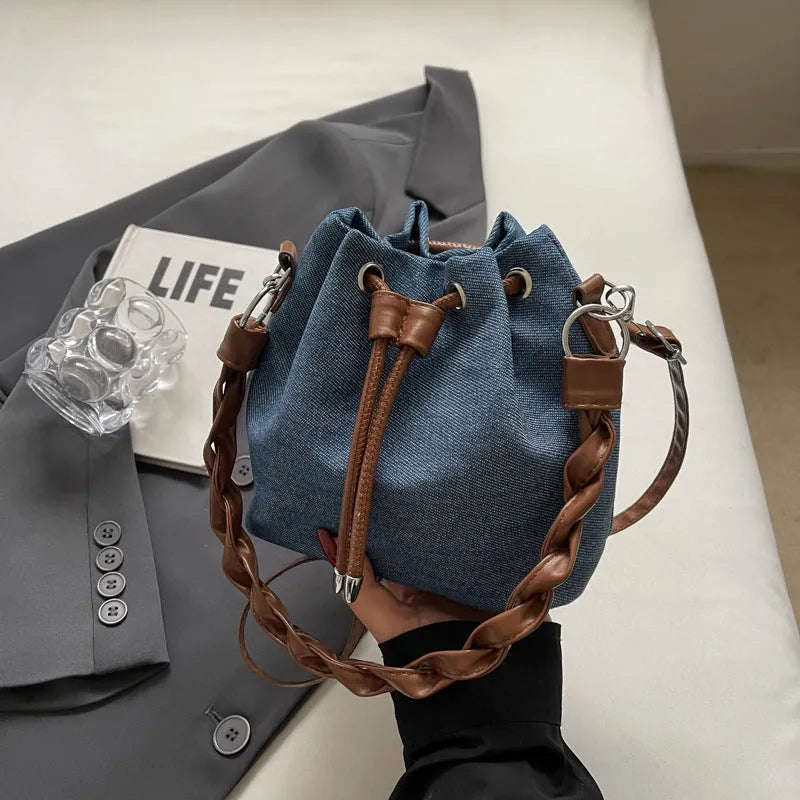 Blue one-shoulder cross body bucket bag with messenger style design and synthetic leather lining