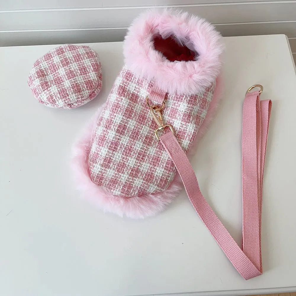 Cat wearing pink beret and matching cloak costume with hand-holding rope