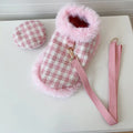 Cat wearing pink beret and matching cloak costume with hand-holding rope