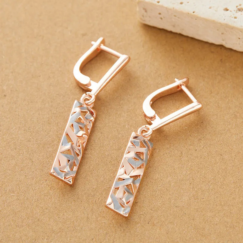 A pair of geometric hollow two-tone stud earrings with a rectangular shape and electroplated alloy finish.