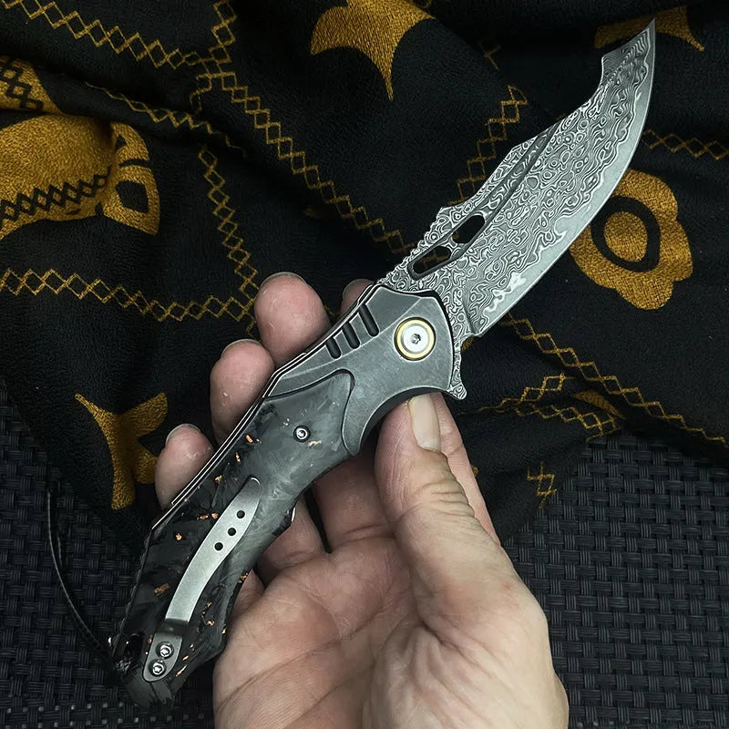 Damascus steel folding knife with carbon fibre handle and 9cm VG10 blade open on wood surface