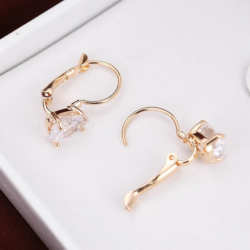 Drop-shaped women's metal earrings with gemstones in gold or platinum colour.