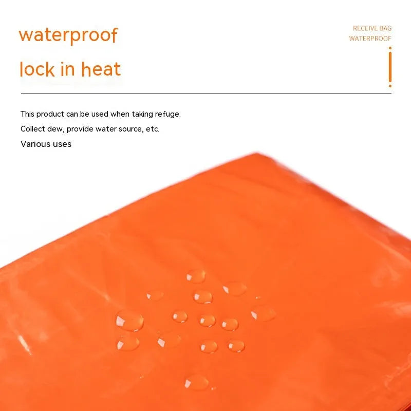 Portable orange disaster relief tent with sleeping bag and emergency blanket setup outdoors