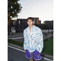 Men's blue embossed floral long sleeve shirt with loose fit on a hanger