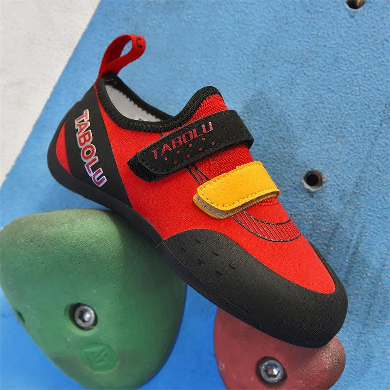 Beginner rock climbing shoes with Velcro strap and wear-resistant rubber sole in black and red colour.