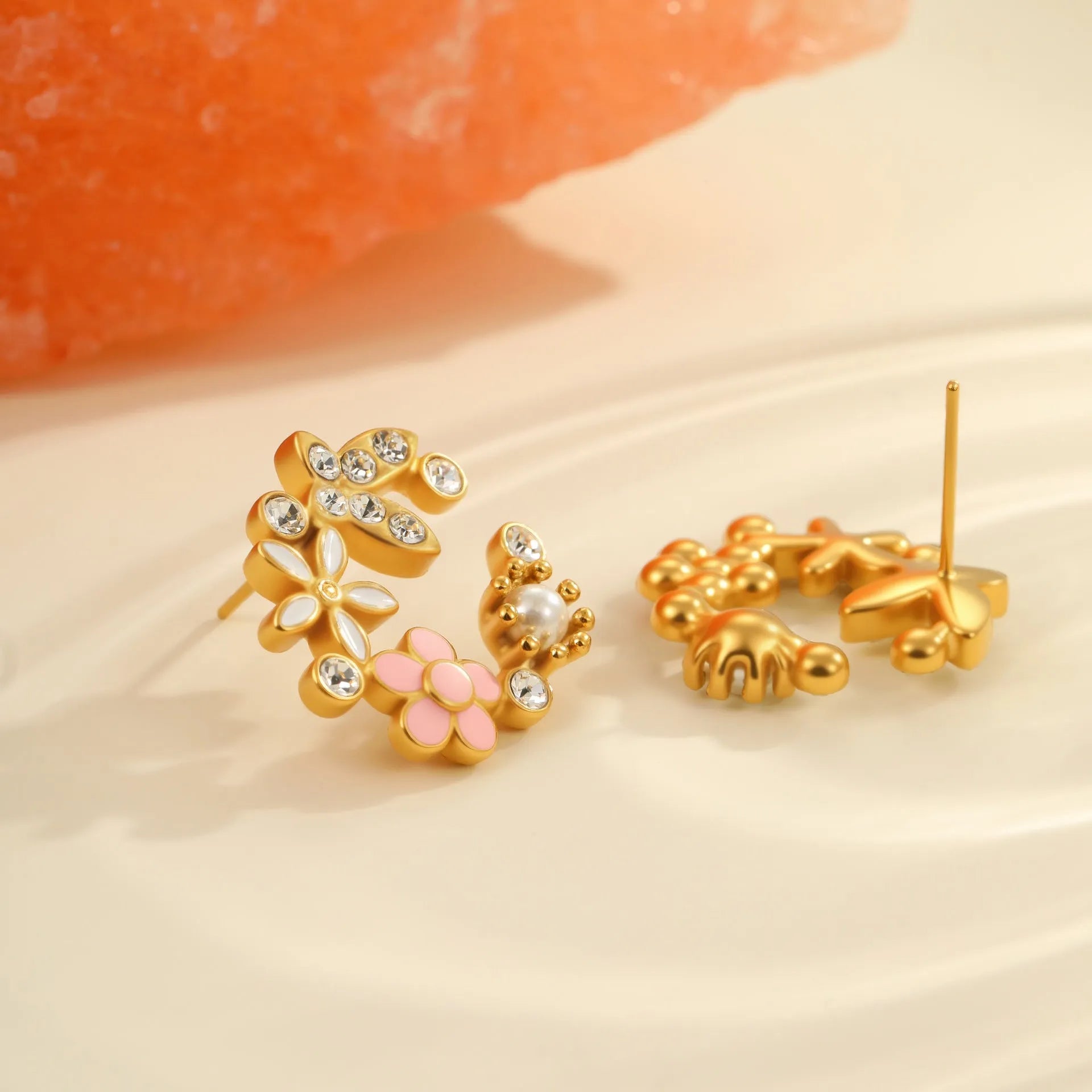 Stainless steel flower stud earrings with colourful oil petals on a white background.