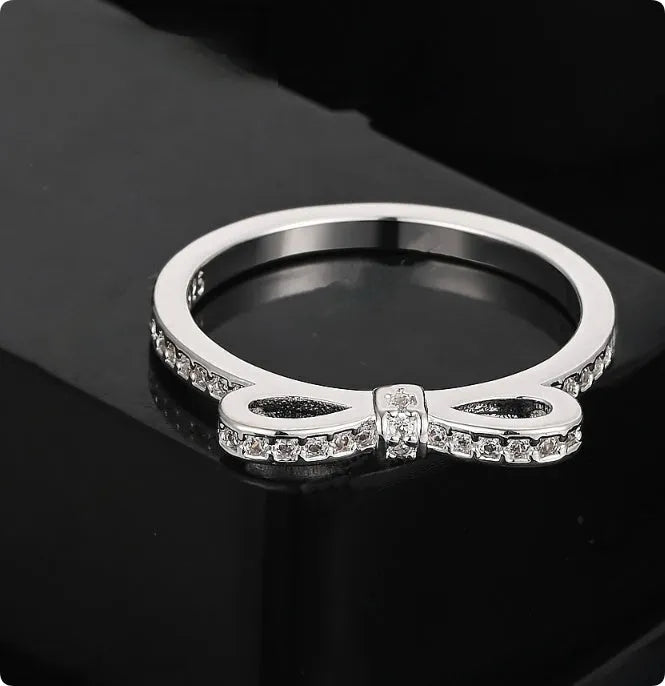 Silver electroplated ring with a bow shape design set with rhinestones and zircon crystals.