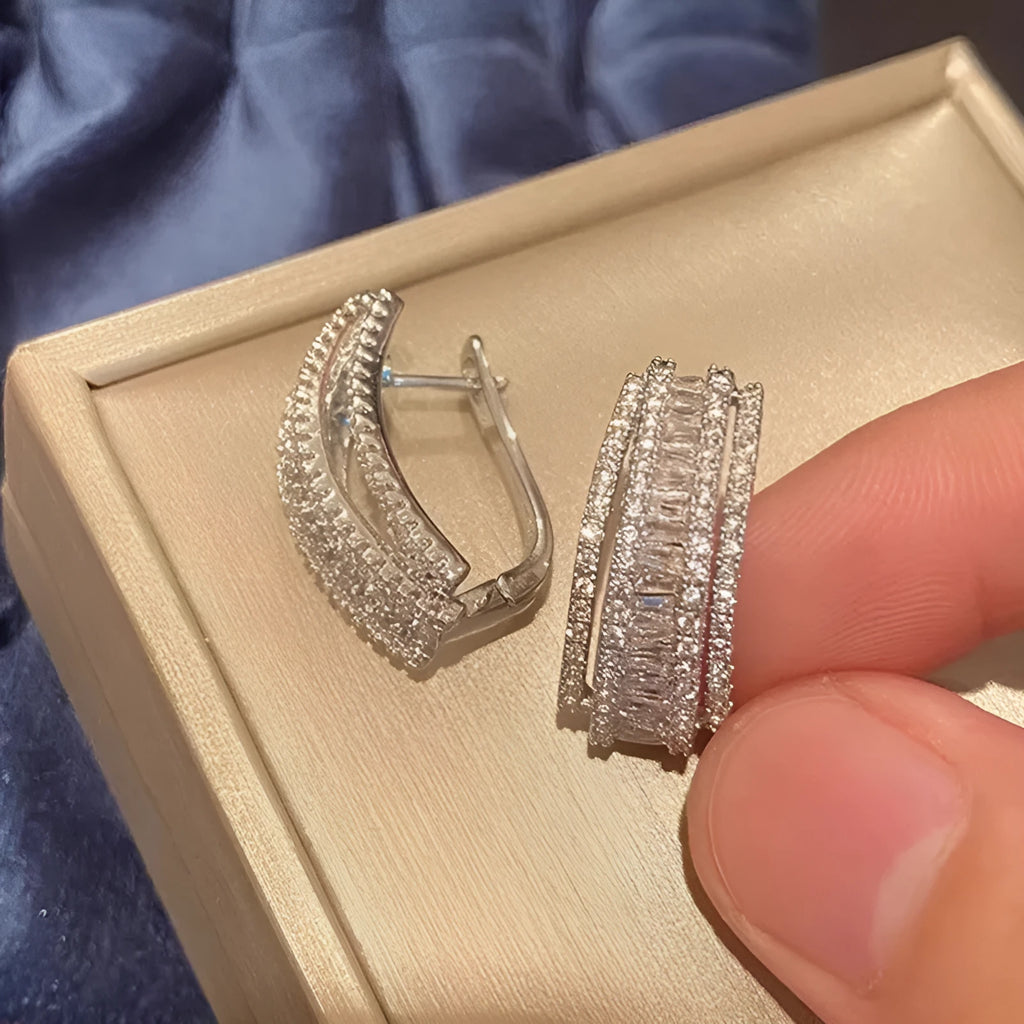A pair of geometric shaped stud earrings with inlaid zircon stones in a white gold colour finish.