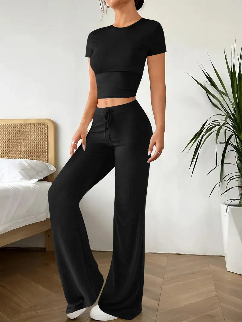 Black women's high waist trousers and short sleeve t-shirt co-ord set on a hanger.