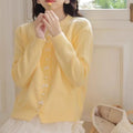 Women's solid colour cardigan with a bow and pearl buttons, shown in a light colour.