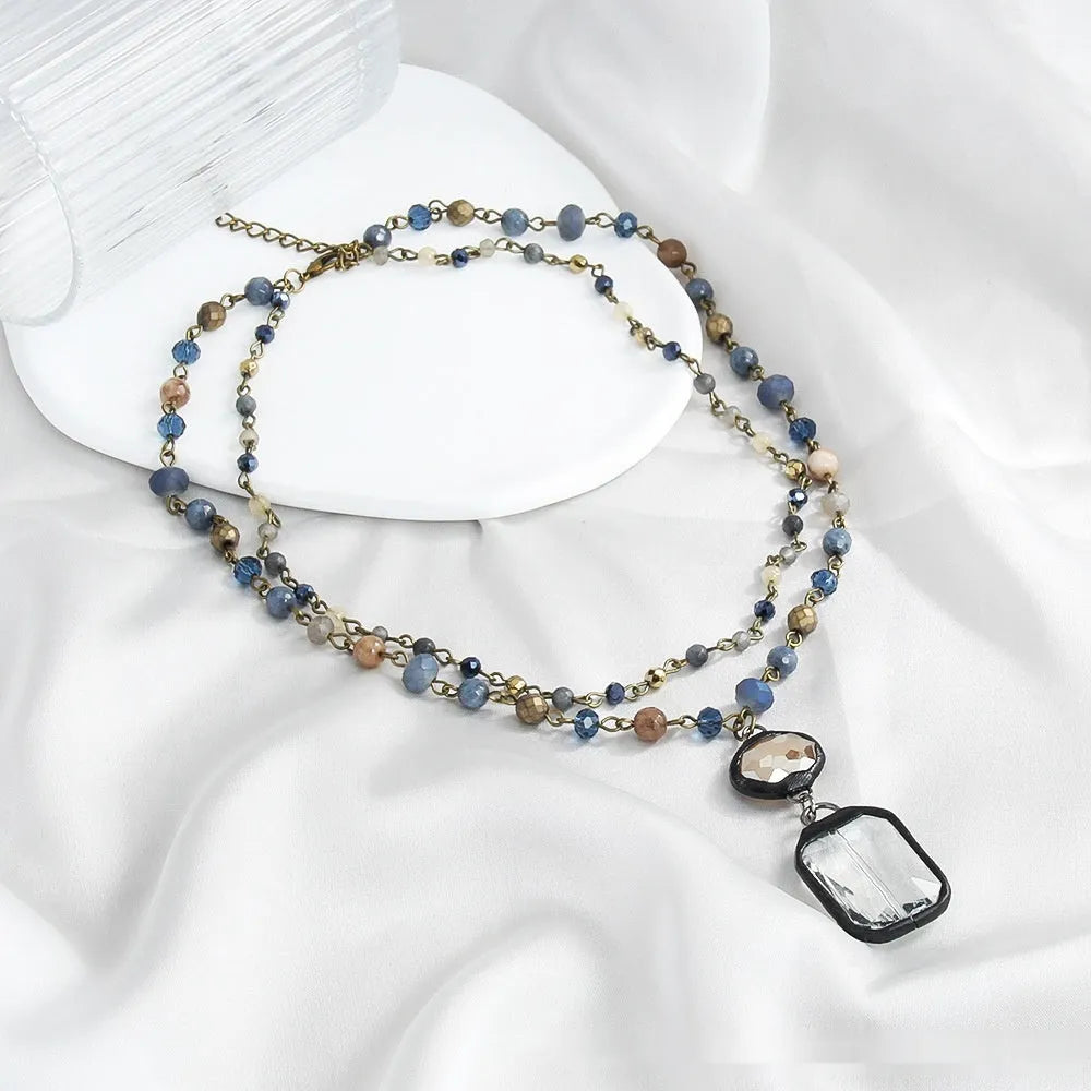 Tribal style necklace with two-layer pendant featuring natural stone and glass elements on chain
