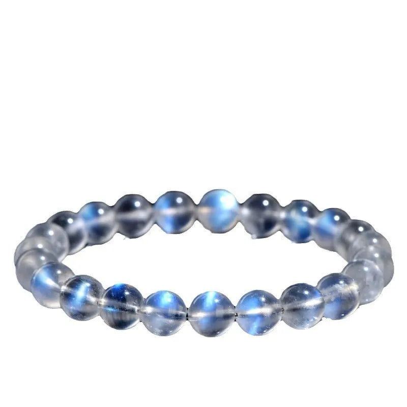 Natural blue moonlight cream body crystal bracelet on a wrist, showing polished beads.