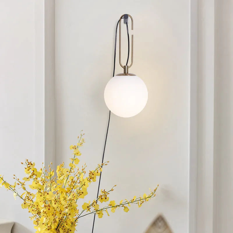 Nordic modern glass wall lamp on a white wall, showing its simple design and diffused light.