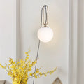 Nordic modern glass wall lamp on a white wall, showing its simple design and diffused light.