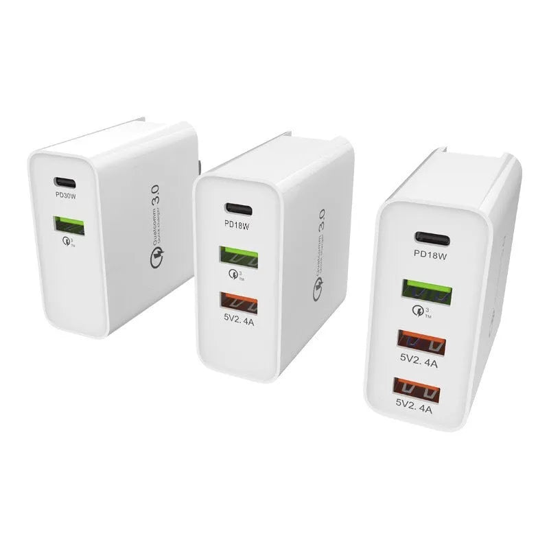 White multi-port fast charger with USB-C and USB-A ports plugged into a wall socket.