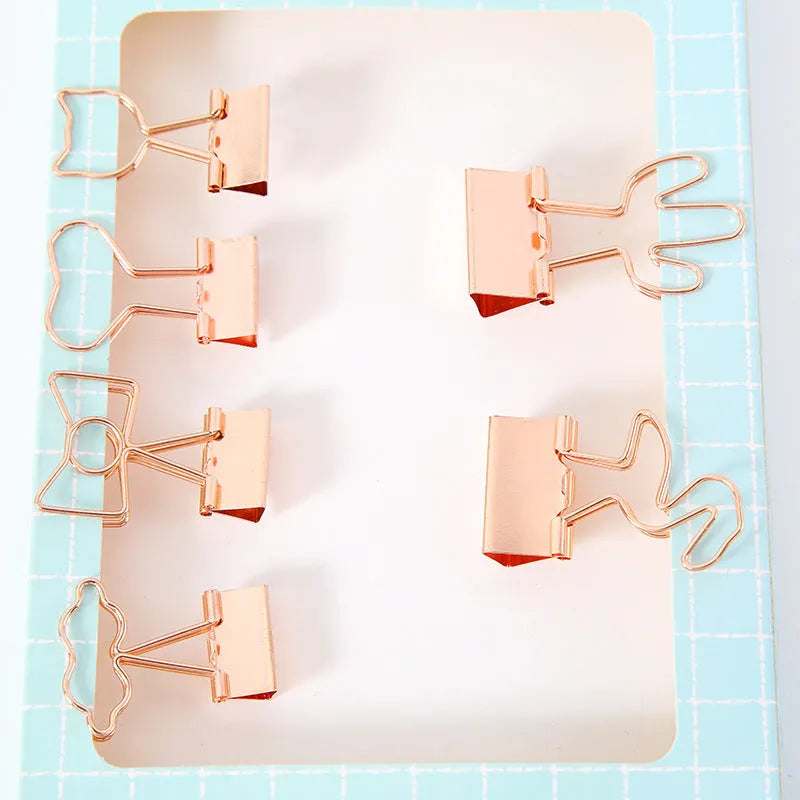 Gold-coloured metal office clip in decorative bow shape design