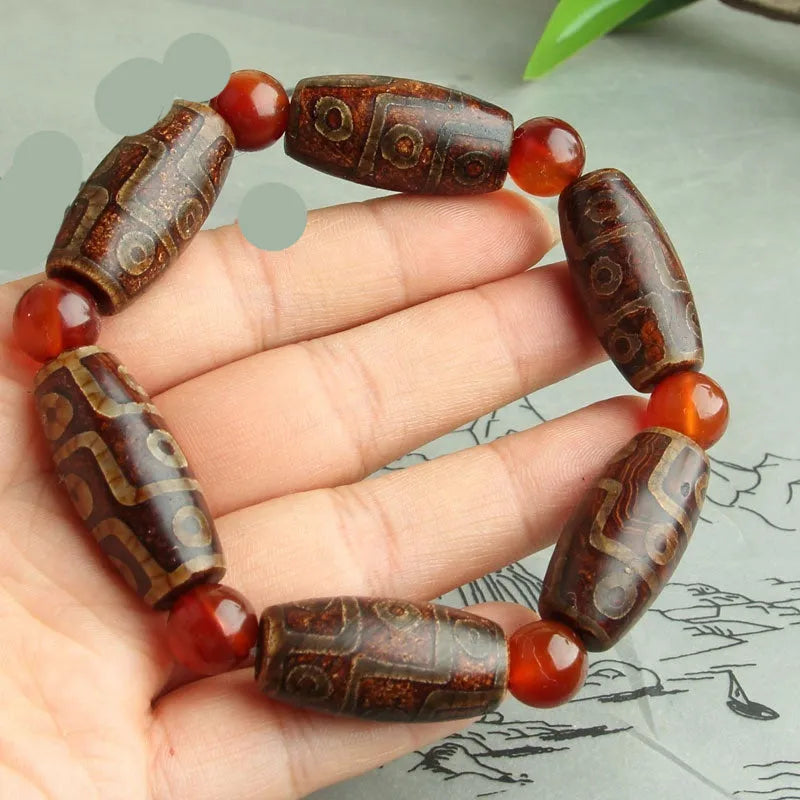 Distressed agate Tibet bead bracelet with three-eye motifs and multiple traditional bead styles on wrist
