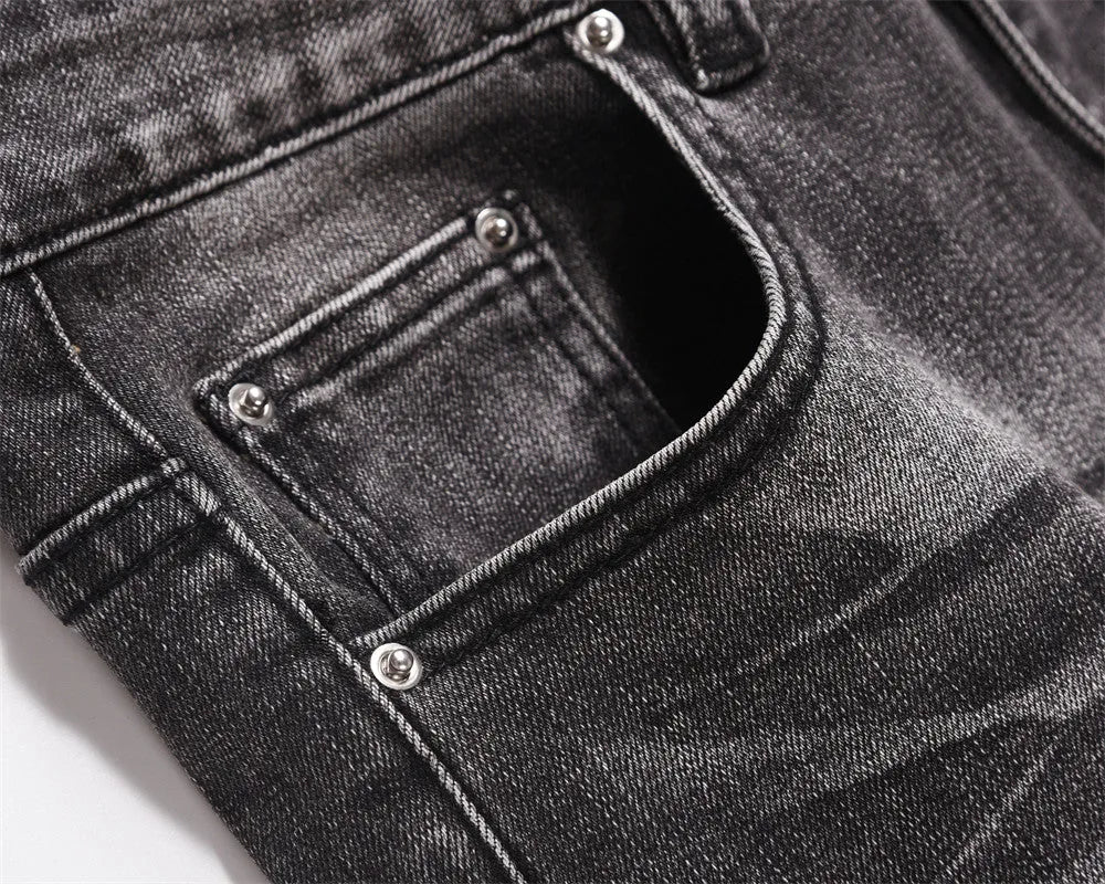 Men's black washed wear-white denim jeans on a plain background showing front view