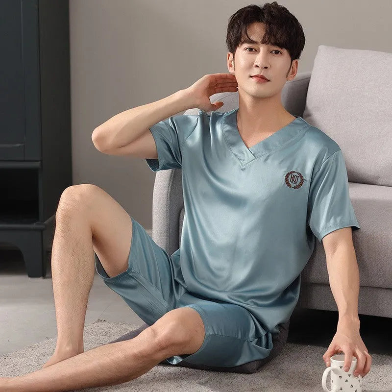 Man wearing a loose light blue short-sleeved ice silk pajama shirt and matching shorts.